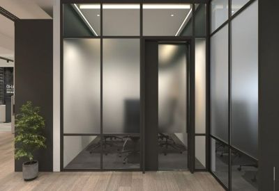 Glass-walled office entrance featuring frosted privacy panels and wooden flooring.