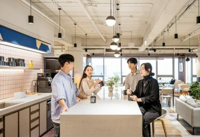 Modern office kitchen island where people are gathering and talking.