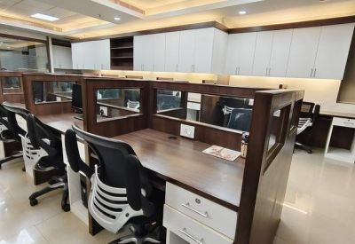 Spacious open-plan office with multiple workstations, wooden partitions, and white storage cabinets.