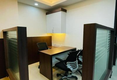 Private office pod with a dark wood desk, ergonomic chairs, and frosted glass partitions.