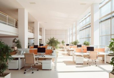 Spacious open-plan office with rows of white desks, ergonomic chairs, and large floor-to-ceiling windows.