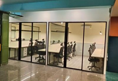 Private glass-partitioned office suites with rows of workstations.