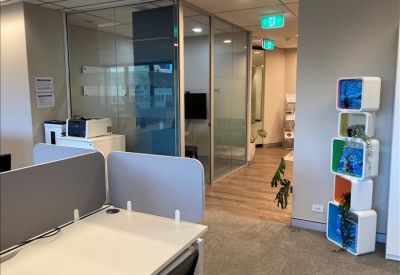Modern office space with semi-private workstations and glass partitions.