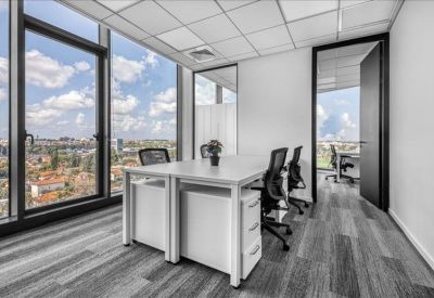 Corner office suite with glass walls and views of the surrounding urban landscape.