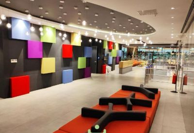 Spacious reception area with colorful geometric wall panels and orange seating.