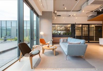 Comfortable lounge area with a light blue sofa, mid-century modern chairs, and a round wooden coffee table.