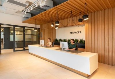 Modern reception area with a long white desk and vertical wood-slat wall paneling.