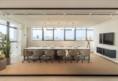 Large conference table with teal chairs and an adjacent floor-to-ceiling wooden shelving unit.