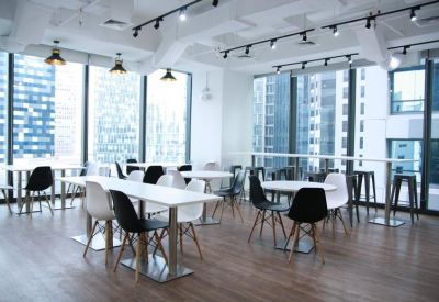 Spacious breakroom with various seating arrangements and floor-to-ceiling city views.