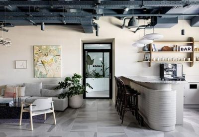 Bright breakout space with a white bar counter, stools, and comfortable seating.