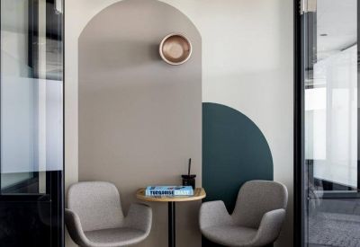 Private room entrance featuring two grey chairs, a small table, and arched wall graphics.