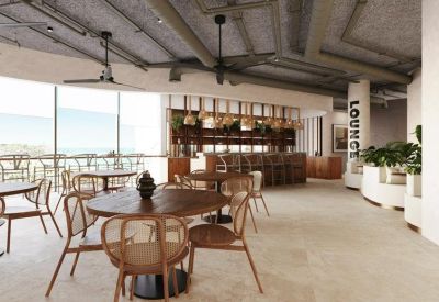 Bright open-plan cafe area with circular wooden tables and floor-to-ceiling windows.