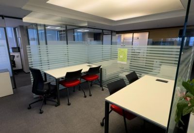 Semi-private workstation with desks and striped frosted glass dividers.