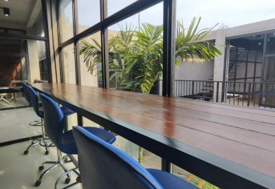 High-top wooden window counter with blue stools overlooking lush garden views.