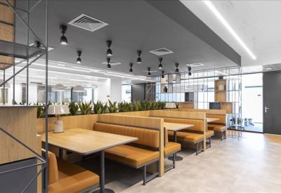 Modern communal dining area with wooden booth seating and industrial pendant lighting.