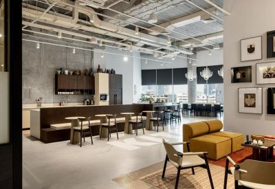 Open-plan kitchen and breakout area with industrial ceilings and modern bistro seating.