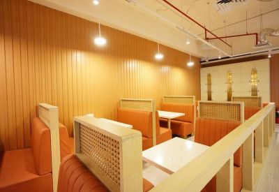 Private dining or work booths with orange leather seating and wooden partitions.
