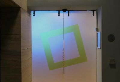 Glass entrance doors with a frosted square logo under the illuminated Bizworld sign.
