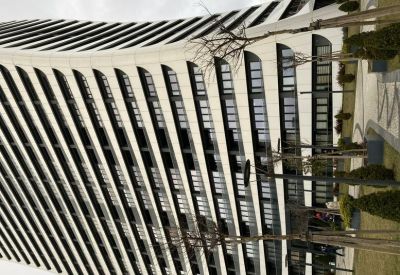 The curved white and glass facade of the Allure Tower building.