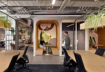 Open-plan workspace with shared desks and an arched seating nook.