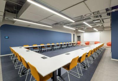 Large U-shaped meeting room with blue walls and orange chairs.