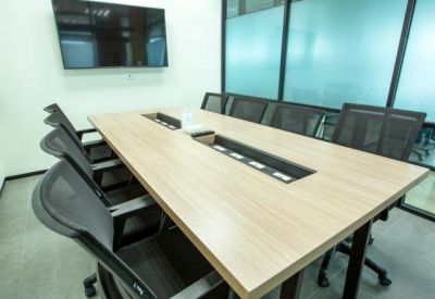 Modern conference room with a long wooden table and ergonomic mesh chairs.