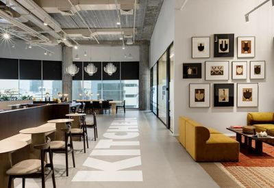 Bright workspace featuring a gallery wall of framed art and white 'KITCHEN' floor lettering.