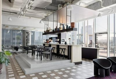 Elevated coffee bar and seating area with panoramic city views through floor-to-ceiling windows.