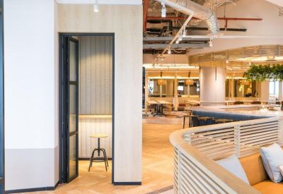 Private phone booth and lounge area with light wood accents and warm parquet flooring.