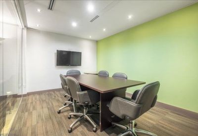 Modern meeting room featuring a lime green accent wall and a dark wood conference table.
