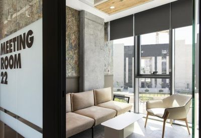 Meeting Room 22 signage on a glass door opening to a bright seating area with floor-to-ceiling windows.