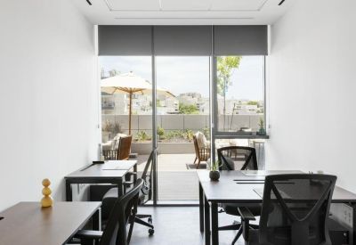 Private office suite with two black desks and a view of the outdoor terrace.
