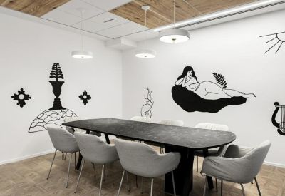 Modern meeting room featuring a long dark table and artistic black and white wall murals.