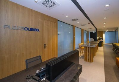 Sleek wooden reception desk with company branding on the wall.
