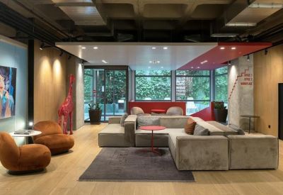 Spacious lounge area with modern sofas, artwork, and a red giraffe statue.