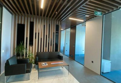 Breakout lounge with comfortable black seating and a warm wood-slat ceiling.