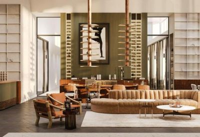 Lounge area with a long velvet sofa and a modern coffee table set against a wood-paneled wall.