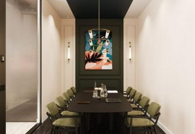 Formal boardroom with a dark table, olive green chairs, and a colorful abstract painting.
