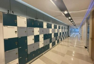 Modern hallway lined with multi-colored storage lockers under a recessed light strip.