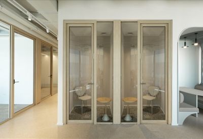 Private glass-enclosed phone booths with minimalist seating.