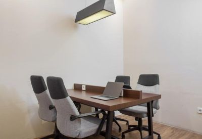 Four-person private office suite with a wood-finished desk and modern lighting.