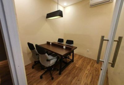 Small private office with wooden flooring and a glass entry door.