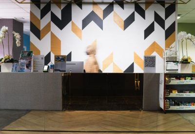 Reception desk with a bold black, white, and gold chevron feature wall.