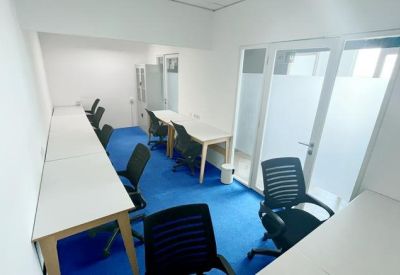 Private office suite with blue carpeting and several white desks.