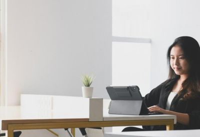 Professional at Jalan Boulevard Artha Gading, RT. 18/RW. 8, Jakarta using a tablet at a white desk.