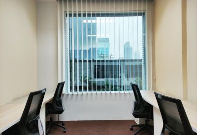 Two-person private office space with desks facing a large window with city views.