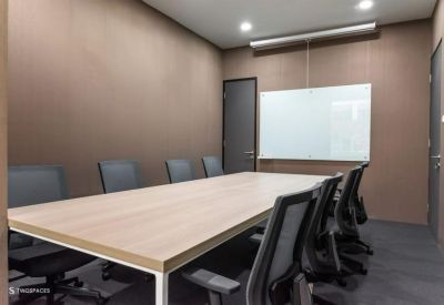 Professional meeting room with a large wooden table, black chairs, and a whiteboard.