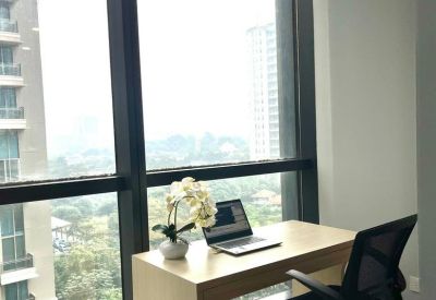 Bright private office featuring a light wood desk, black task chair, and floor-to-ceiling city views.