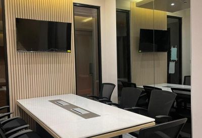 Modern meeting room with a white marble table, black ergonomic chairs, and wood-paneled walls.