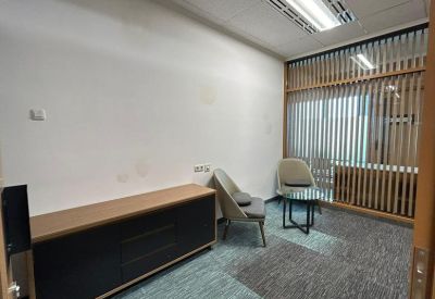 Small, private meeting room with two grey armchairs and a slatted wood partition.